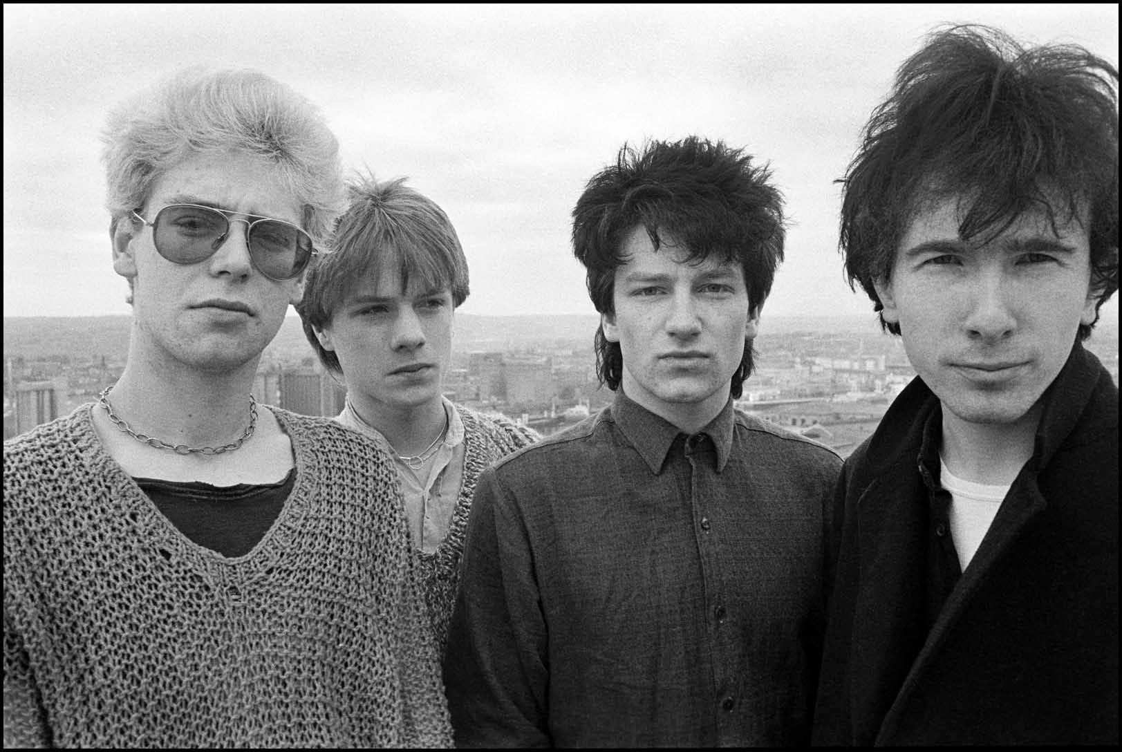 U2 standing on rooftop in Corke, Ireland. 1980