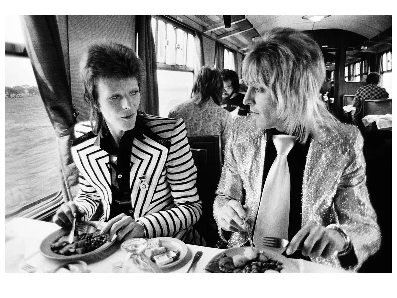 David Bowie and Mick Ronson on train to Aberdeen, Scotland. 1973