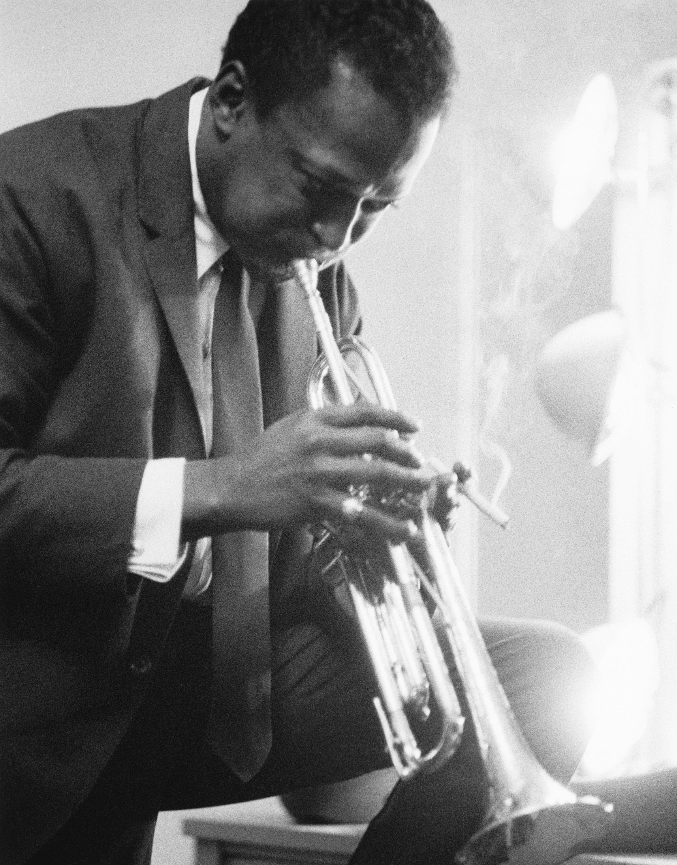 American jazz musician, bandleader and composer Miles Davis playing the trumpet in a dressing room before a performance.