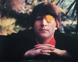 Portrait of John Lennon with a flower in his eye taken in Weybridge, England in 1965.