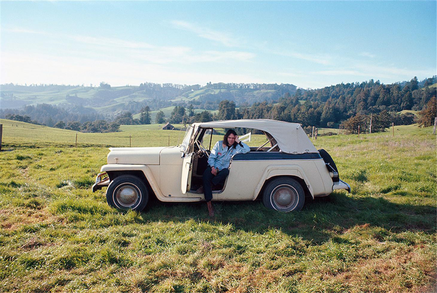 Neil Young sitting in his Willys-Overland Jeepster Broken Arrow Ranch, February 1971