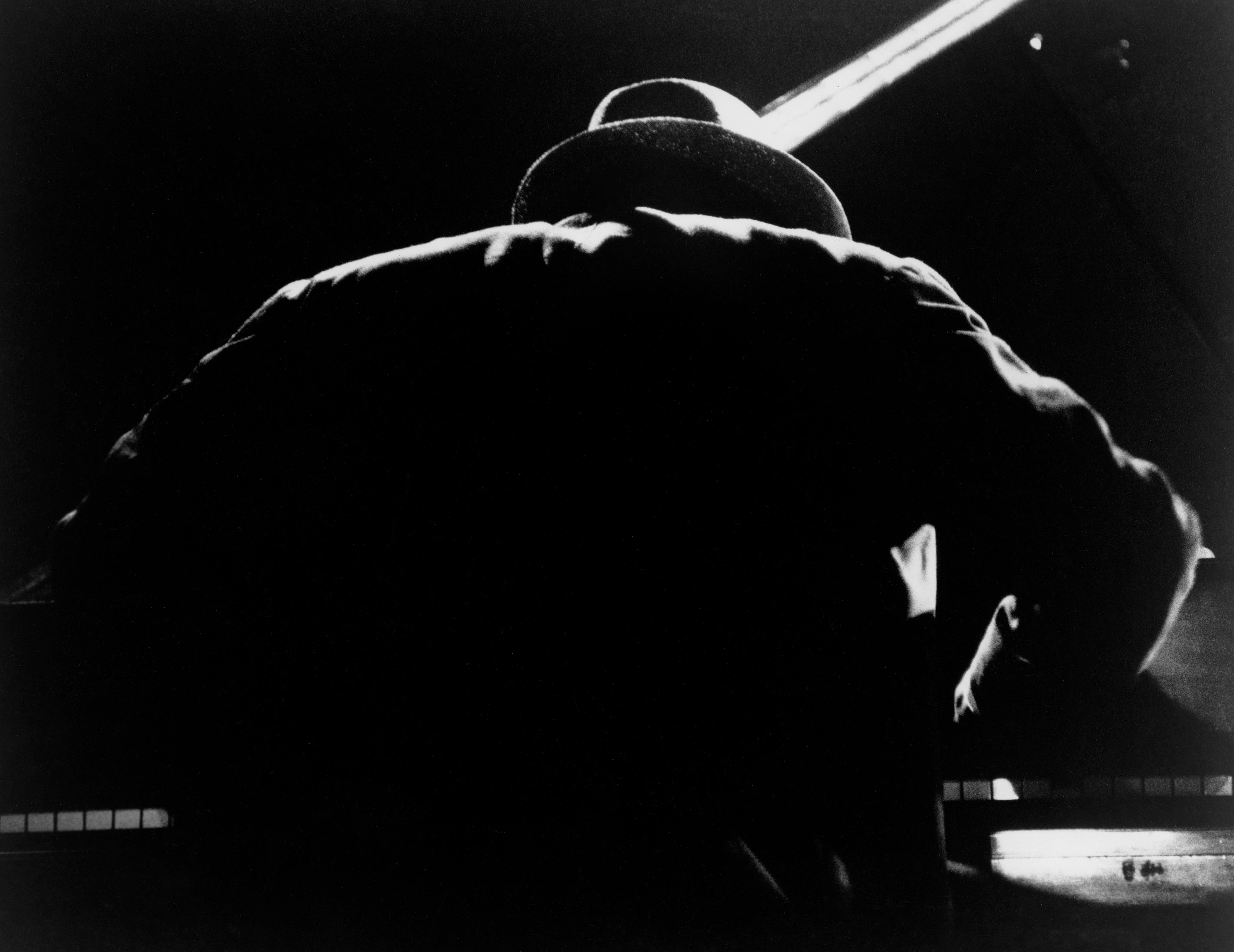 Silhoulette of American jazz pianist and composer Thelonious Monk performong on stage at Newport Jazz Festival, Rhode Island, 1958.