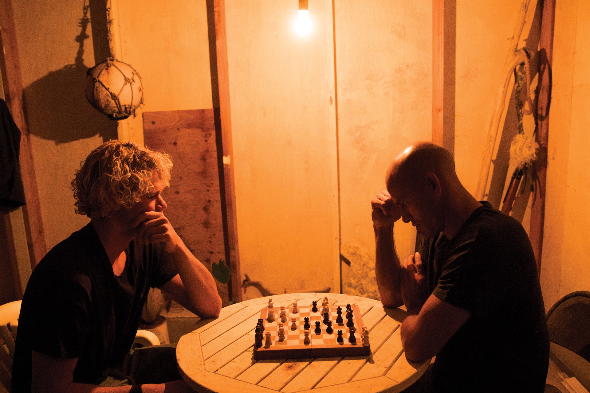 John John Florence and Kelly Slater playing chess.