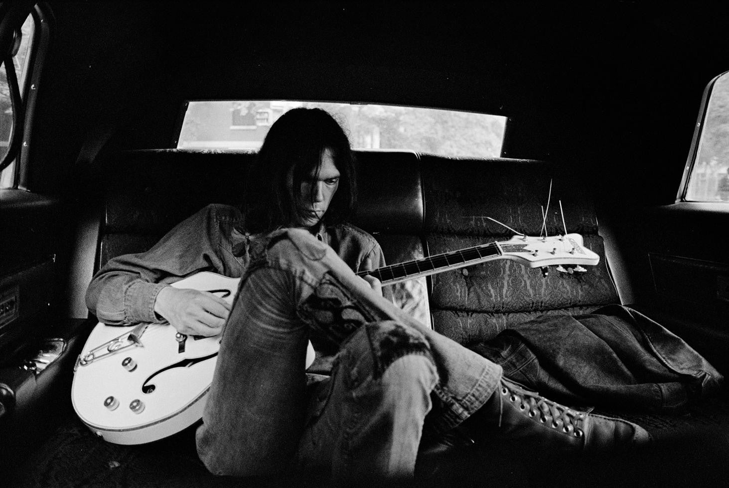Neil Young in a limo with Gretsch White Falcon guitar NYC, June 1970.