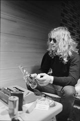 Warren Zevon sitting on couch, 1977.