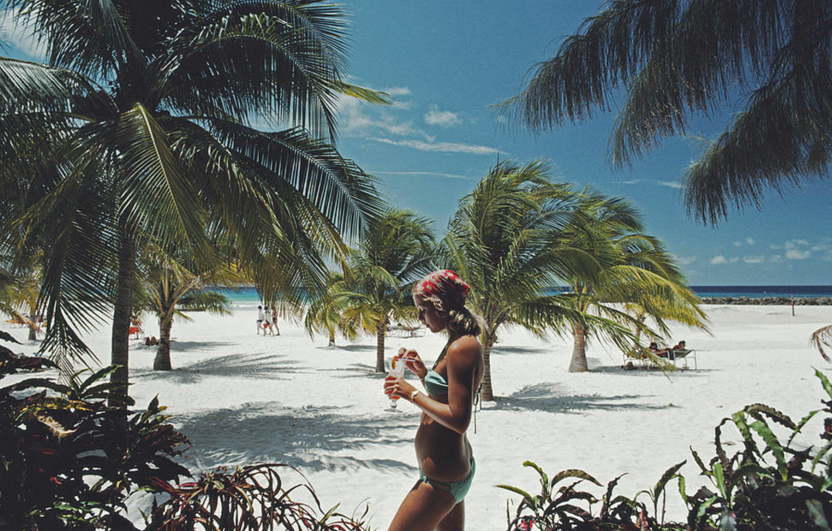 Sarah Marson Williams enjoys a cocktail on the beach at the Hilton Hotel, Needhams Point, Barbados, April 1976.