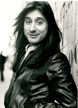 Steve Perry of Journey posing in front of the KLM offices during renovation on the Leidseplein, Amsterdam, 1977.