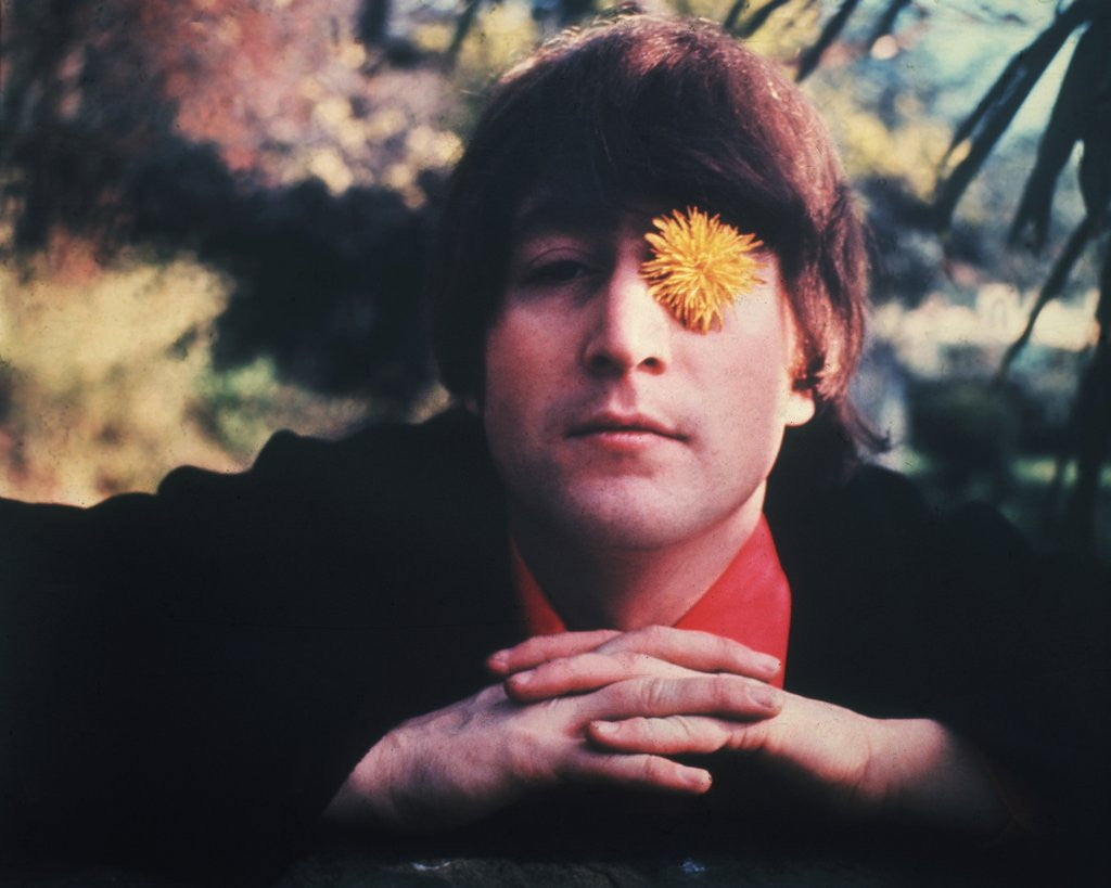 Portrait of John Lennon with a flower in his eye taken in Weybridge, England in 1965.