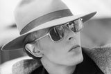 Singer David Bowie wearing a smart hat and sunglasses during the filming of ‘The Man Who Fell To Earth’ in Los Angeles, 1976.