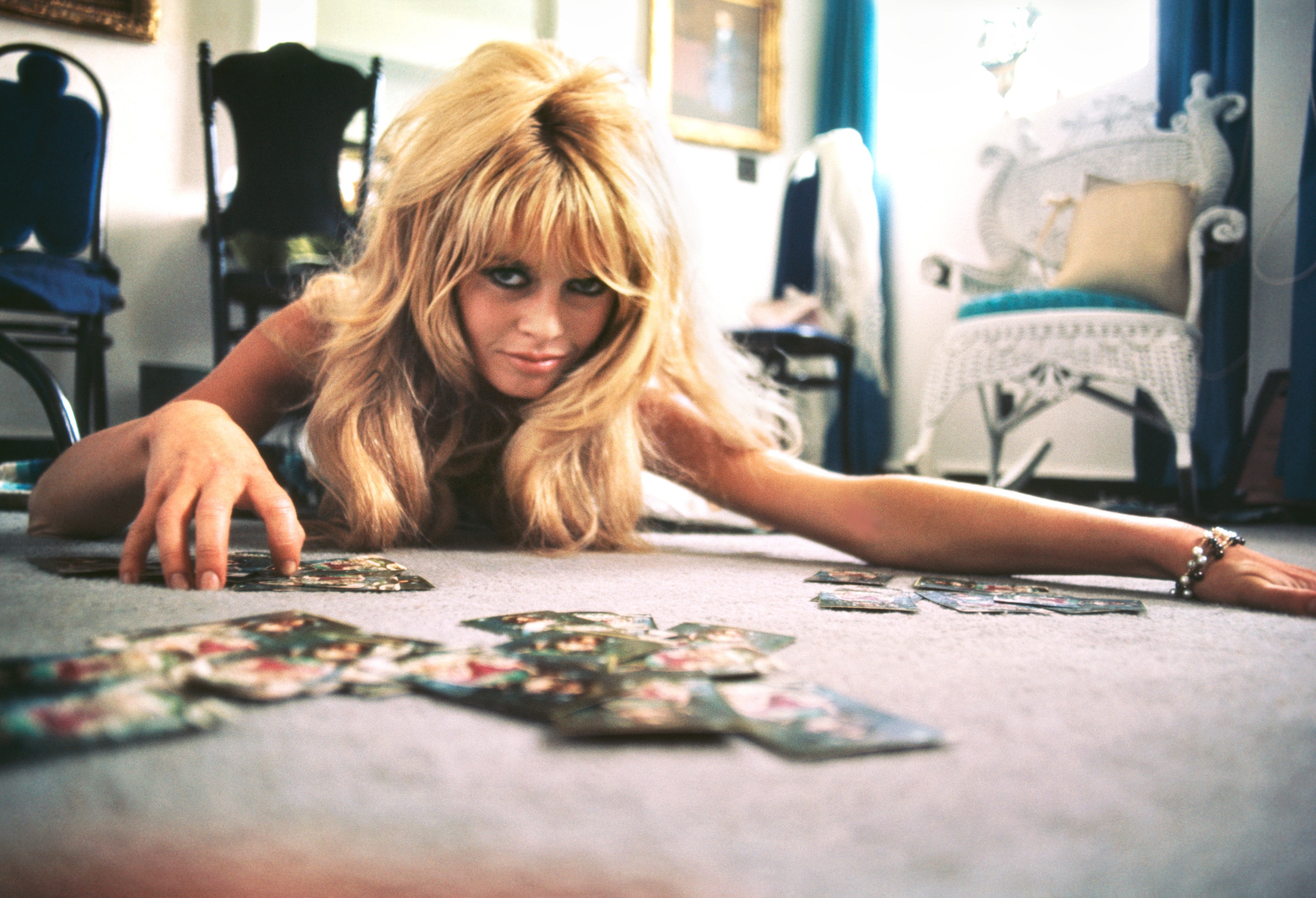 French actress Brigitee Bardot plays cards on set of the comedy-adventure film ‘Viva Maria’, 1965.
